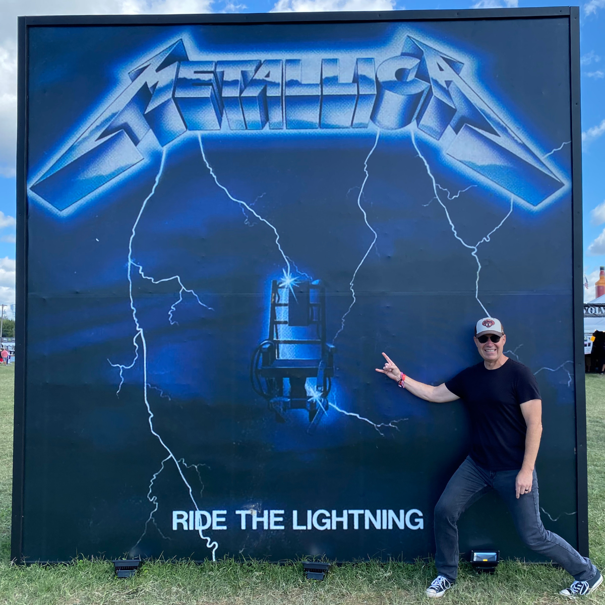 Colin Conway standing in front of Metallica promo at Louder than Life festival